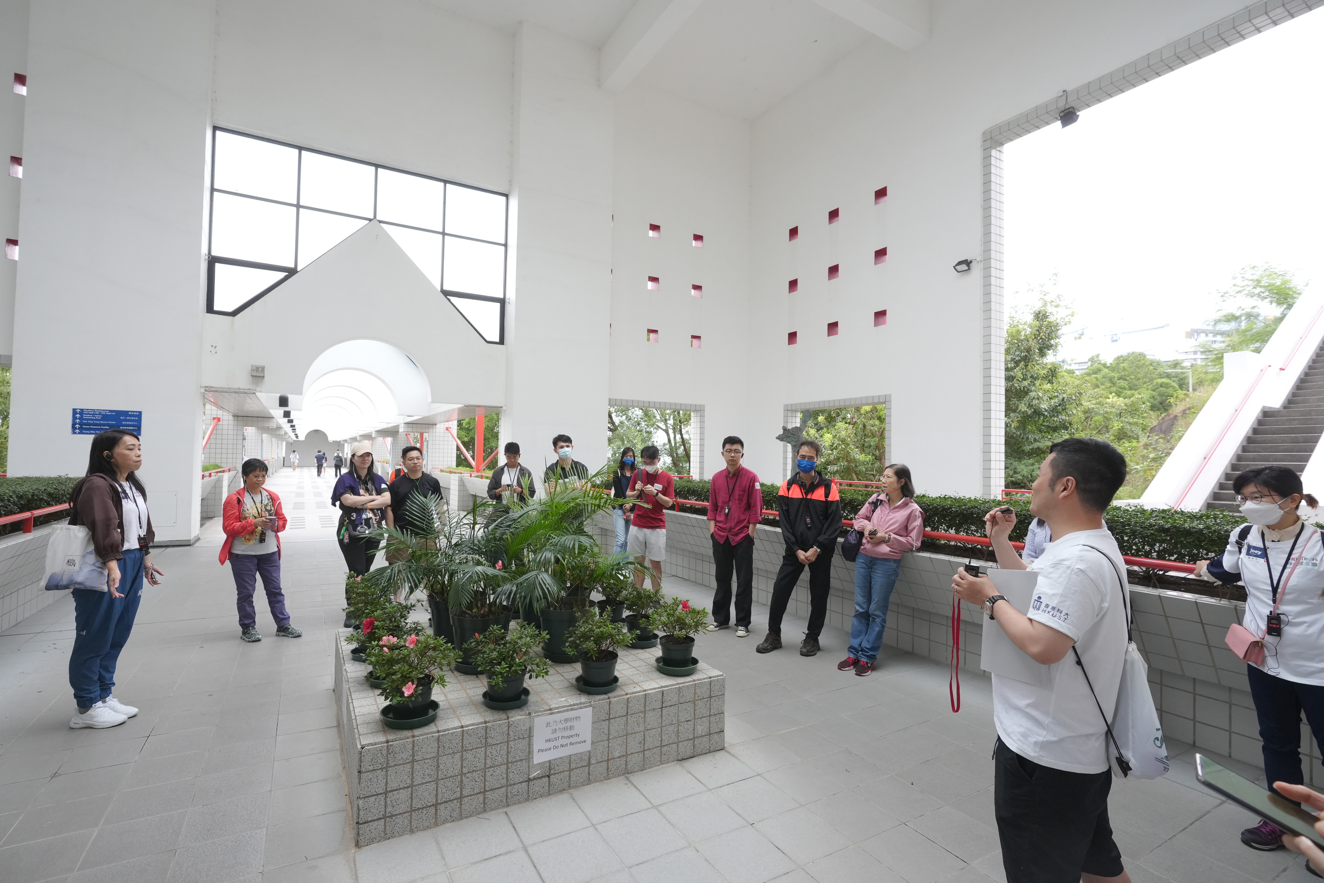 另一個由科大校友帶領的導賞團穿梭校園各處，介紹各個景點和他們背後的故事。圖中的景點是智慧石，是位於通住海邊連接橋的方形大石，相傳學生如果能成功跳過智慧石，成績便可「過三爆四」，如跳不過則會因成績退步而被踢出校。
