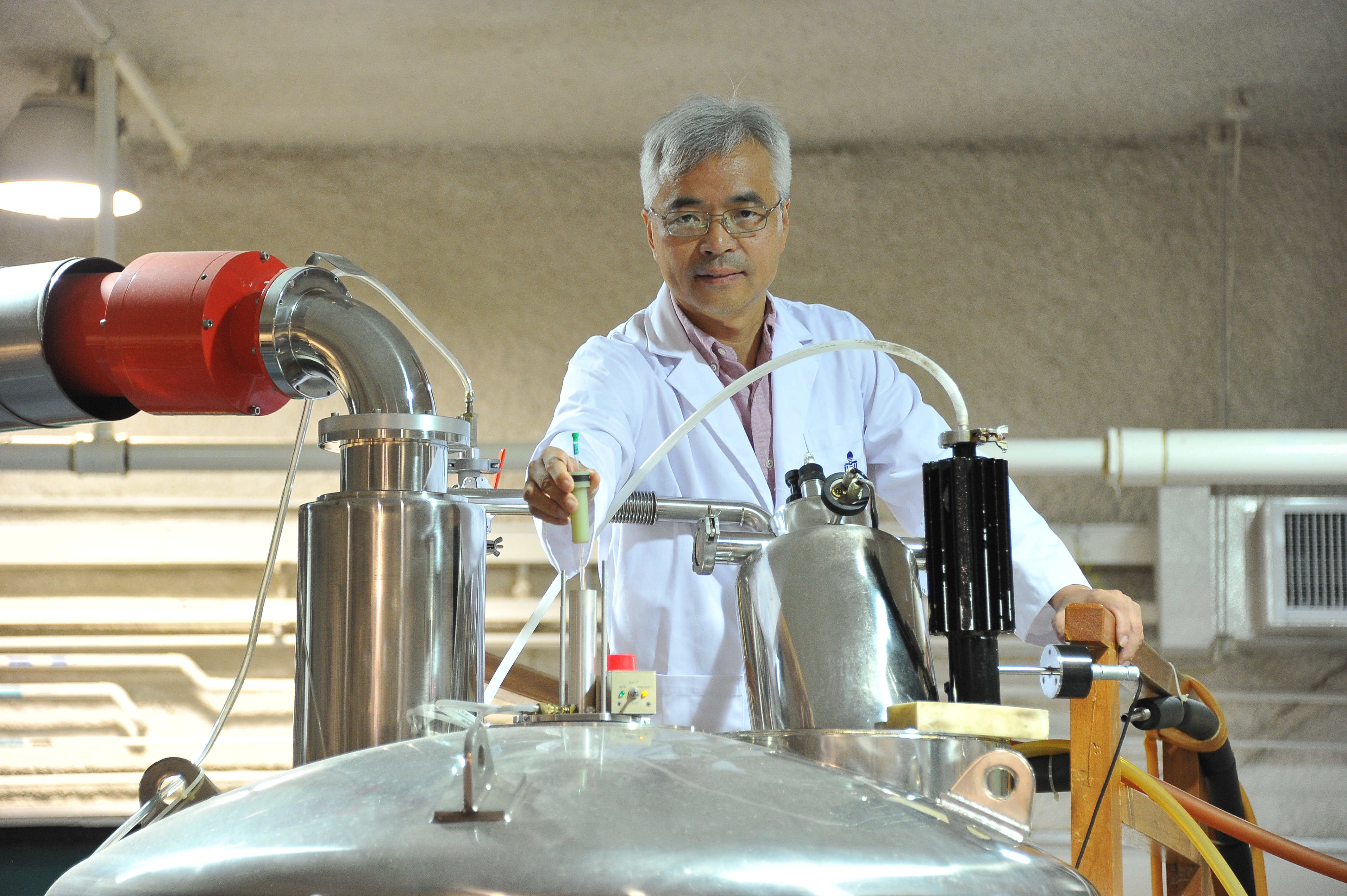  Prof Zhang puts a protein sample into the Nuclear Magnetic Resonance Spectrometer to investigate its molecular structure